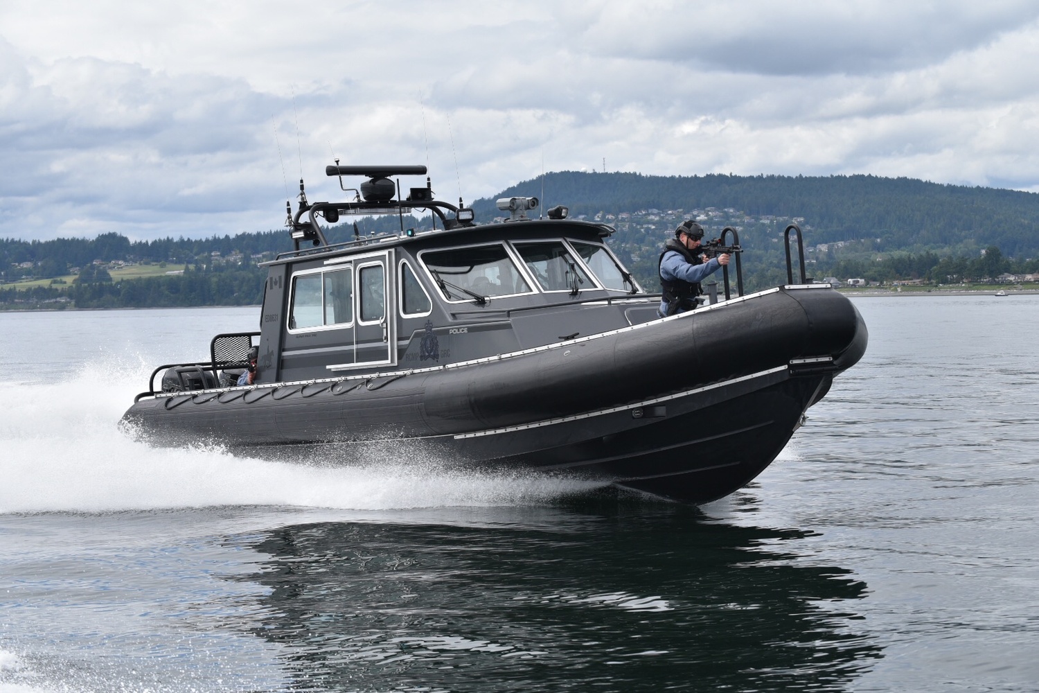 Police force boat with tactical officer and mounted surveillance camera.